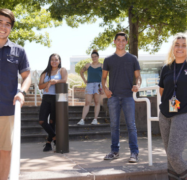 A small group of people standing in an outdoor area on a sunny day