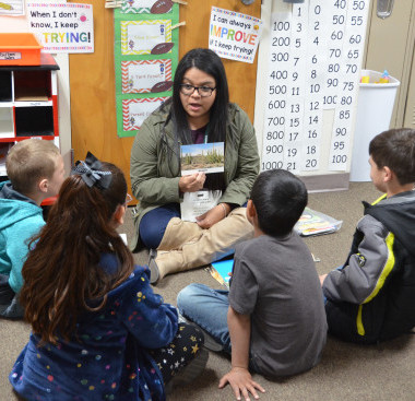 Teacher and students sitting on the floor